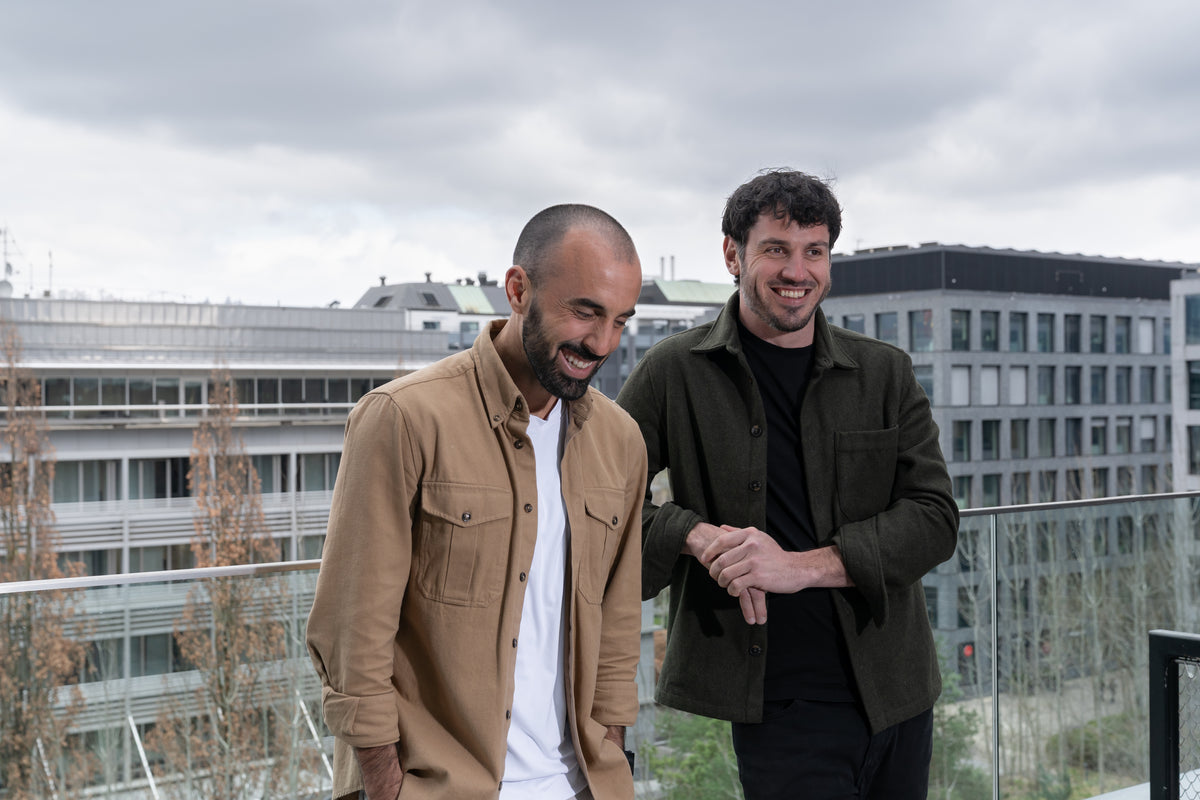 Die beiden Gründer der HUX Agency lachend auf einer Dachterrasse in Zürich